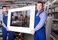 Serious male professional labours with finished PVC profiles and Royalty Free Stock Photo