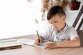 serious male student doing handwritten homework in a notebook while sitting in class at the table. Preparing an Royalty Free Stock Photo