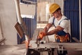 Serious male worker using woodworking machine in workshop Royalty Free Stock Photo