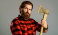 Serious man with axe. Bearded lumberjack with ax. Male in checkered shirt with hatchet. Logger tool. Royalty Free Stock Photo