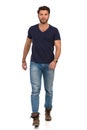 Serious Man In Blue T-shirt, Jeans And Boots Is Walking Towards Camera Royalty Free Stock Photo