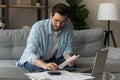 Serious man calculates expenses working sit on sofa at home Royalty Free Stock Photo