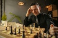 Serious man chess player sitting at home and playing chess alone. Royalty Free Stock Photo