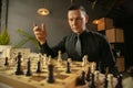 Serious man chess player sitting at home and playing chess alone. Royalty Free Stock Photo