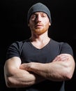 Serious man with crossed arm posing on black. Handsome confident and serious guy in studio.