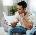 Serious man, documents and thinking for debt or planning in decision on living room sofa at home. Male person with Royalty Free Stock Photo