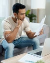 Serious man, documents and thinking in finance, debt or stress for decision on living room sofa at home. Male person Royalty Free Stock Photo