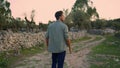 Serious man examining garden closeup. Guy walking olive trees plantation alone