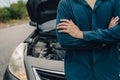 Serious man fold oneÃ¢â¬â¢s arms over the chest front of car breakdown and open bonnet on roadside. Car broken concept Royalty Free Stock Photo