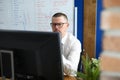 Serious man in glasses and shirt sit and look at computer monitor. Royalty Free Stock Photo