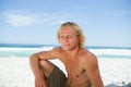 Serious man sitting on the beach while looking towards the side Royalty Free Stock Photo