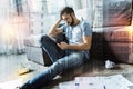 Serious man sitting on the floor and feeling tired of work Royalty Free Stock Photo