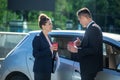 Serious man and smiling woman with glasses of coffee near car Royalty Free Stock Photo