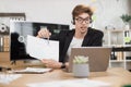 Serious man in suit talking to client on video call, presenting paper graphic reports Royalty Free Stock Photo