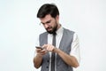 Serious man in suit typing sms on smartphone