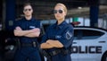 Serious man and woman police officers in sunglasses standing outdoor, safety