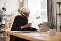 Serious marketing african man in suit and headset talking to client on video call Royalty Free Stock Photo