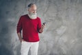 Serious masculine modern old man stand copyspace use smartphone search x-mas season discounts type newyear