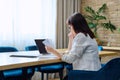 Serious mature businesswoman reading official letter, sitting in office