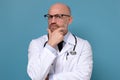 Serious mature doctor man thinking standing with arms folded Royalty Free Stock Photo