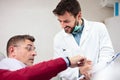 Serious mature man consulting with his doctor in medical clinic