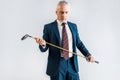 Serious mature man in suit holding golf club isolated Royalty Free Stock Photo