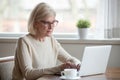 Serious mature middle aged business woman using laptop typing em Royalty Free Stock Photo