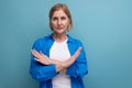 serious mature woman disagree on blue background with copyspace