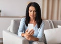 Serious mature woman using smartphone at her home Royalty Free Stock Photo