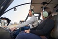 Focused man in safety gear flying a helicopter with kid