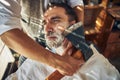 Handsome young man being shaved with an axe Royalty Free Stock Photo