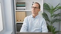 Serious middle-aged man doubting ideas while concentrating on his laptop work in a professional office space