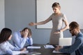 Serious businesswoman ask failed employee to leave meeting