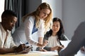 Serious millennial female team leader presenting research results to colleagues.