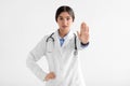 Serious millennial hindu female doctor in coat showing stop hand gesture, isolated on white background