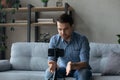 Serious millennial man taking video on mobile phone on tripod