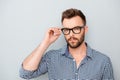 Serious minded young businessman touching his glasses Royalty Free Stock Photo