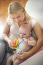 Serious mother playing with baby boy at home.