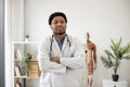 General practitioner in white coat posing in doctor's office Royalty Free Stock Photo
