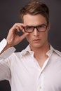 Serious, nerd and portrait of man with glasses, fashion or eyewear in dark background of studio. Optometry, healthcare