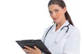 Serious nurse writing on clipboard and looking at camera Royalty Free Stock Photo