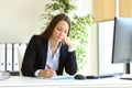 Serious office worker writing on document