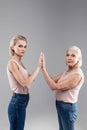 Peremptory young lady and old grey-haired woman raising hands