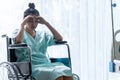 Serious patient sitting on wheelchair in hospital. Royalty Free Stock Photo