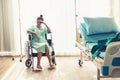 Serious patient sitting on wheelchair in hospital. Royalty Free Stock Photo