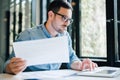 Serious pensive thoughtful focused young casual business accountant bookkeeper in office looking at and working with laptop and Royalty Free Stock Photo