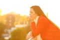 Serious pensive woman in a balcony in winter at sunset