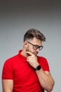 Serious pensive young man businessman in glasses thinking, solving problems, studio portrait on gray with copy space Royalty Free Stock Photo