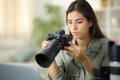 Serious photographer checking camera at home