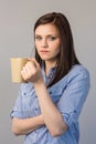 Serious pretty brunette holding cup of coffee Royalty Free Stock Photo